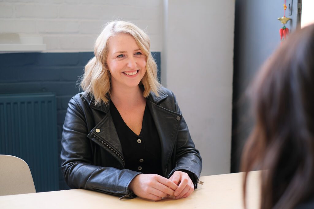 A woman sitting at a table with another person.