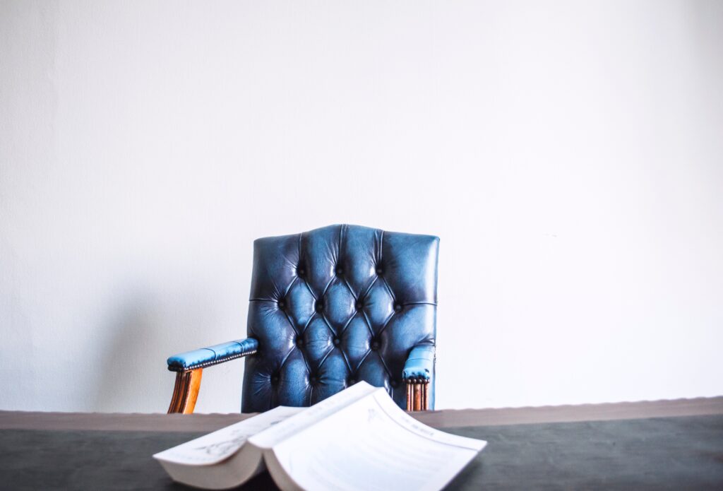 A blue chair and some papers on the table
