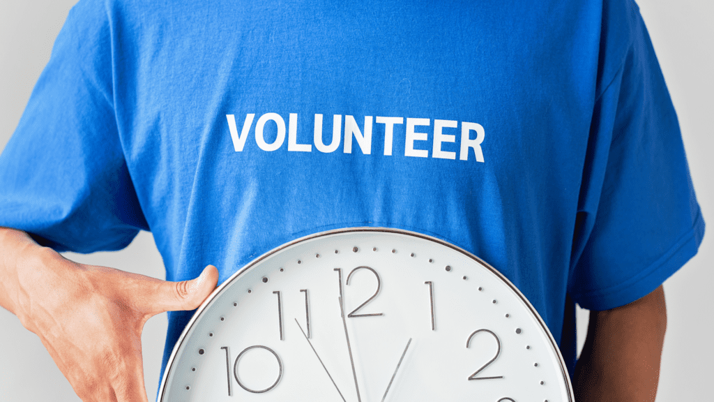 A person holding a clock with the word volunteer on it.