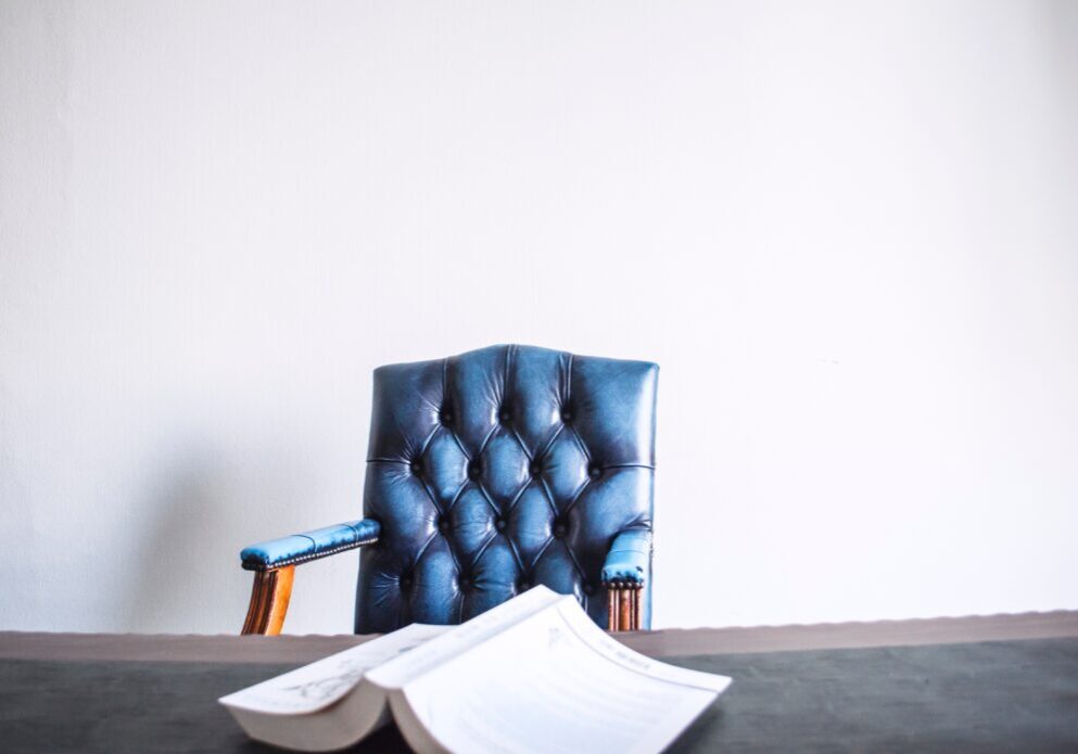 A blue chair and some papers on the table